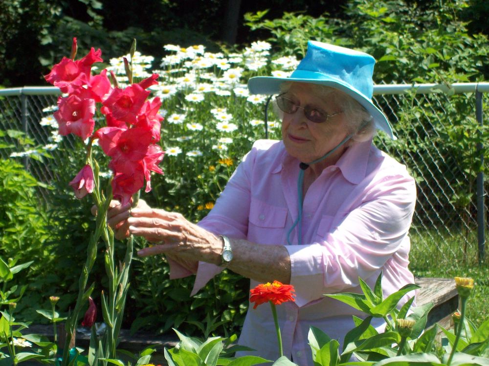 senior resident tending to flowers in garden