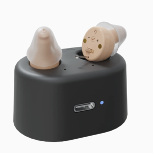 beige hearing aids in a black charging dock