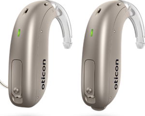 beige hearing aids with green light illuminated 