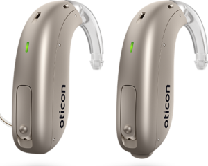 beige hearing aids with green light illuminated 